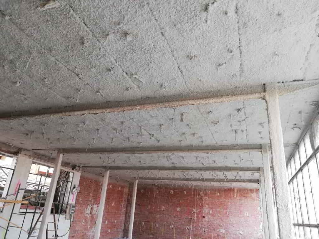 Forjado y vigas de un edificio en rehabilitación protegidos con aislamiento ignífugo proyectado