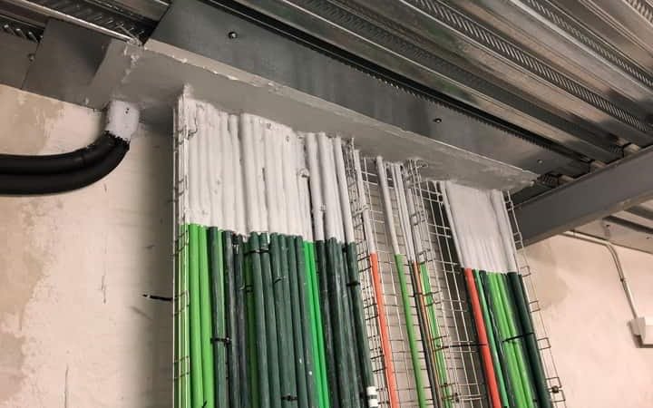 Sellado cortafuegos del paso de bandejas de cables y tubos a través de un muro de sector de incendio